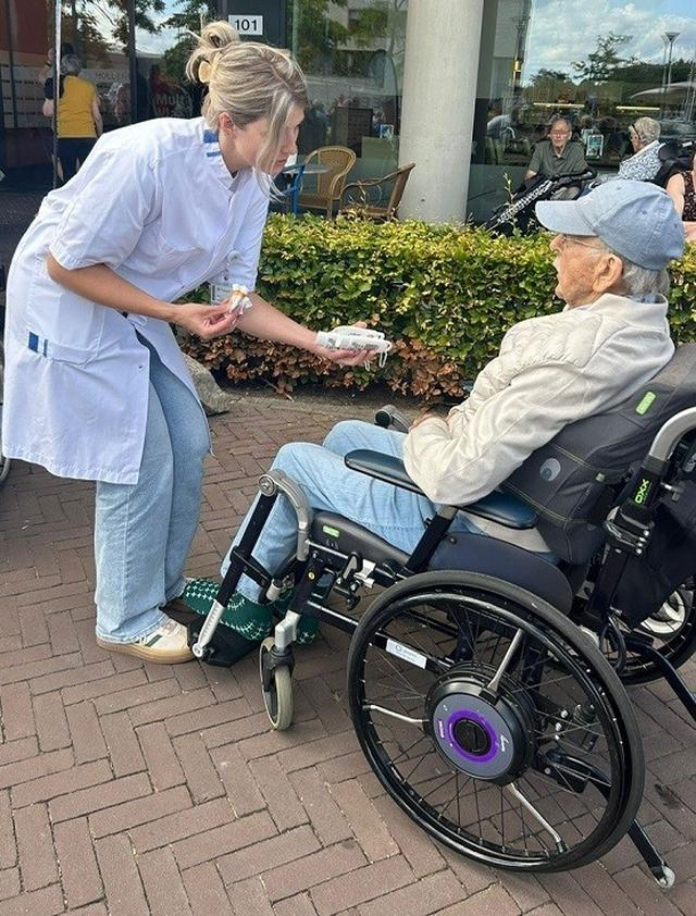 Lorena Tieben deelt zonnebrandcreme uit tijdens de wandel2daagse van woonzorgcentrum Holdert van Treant.