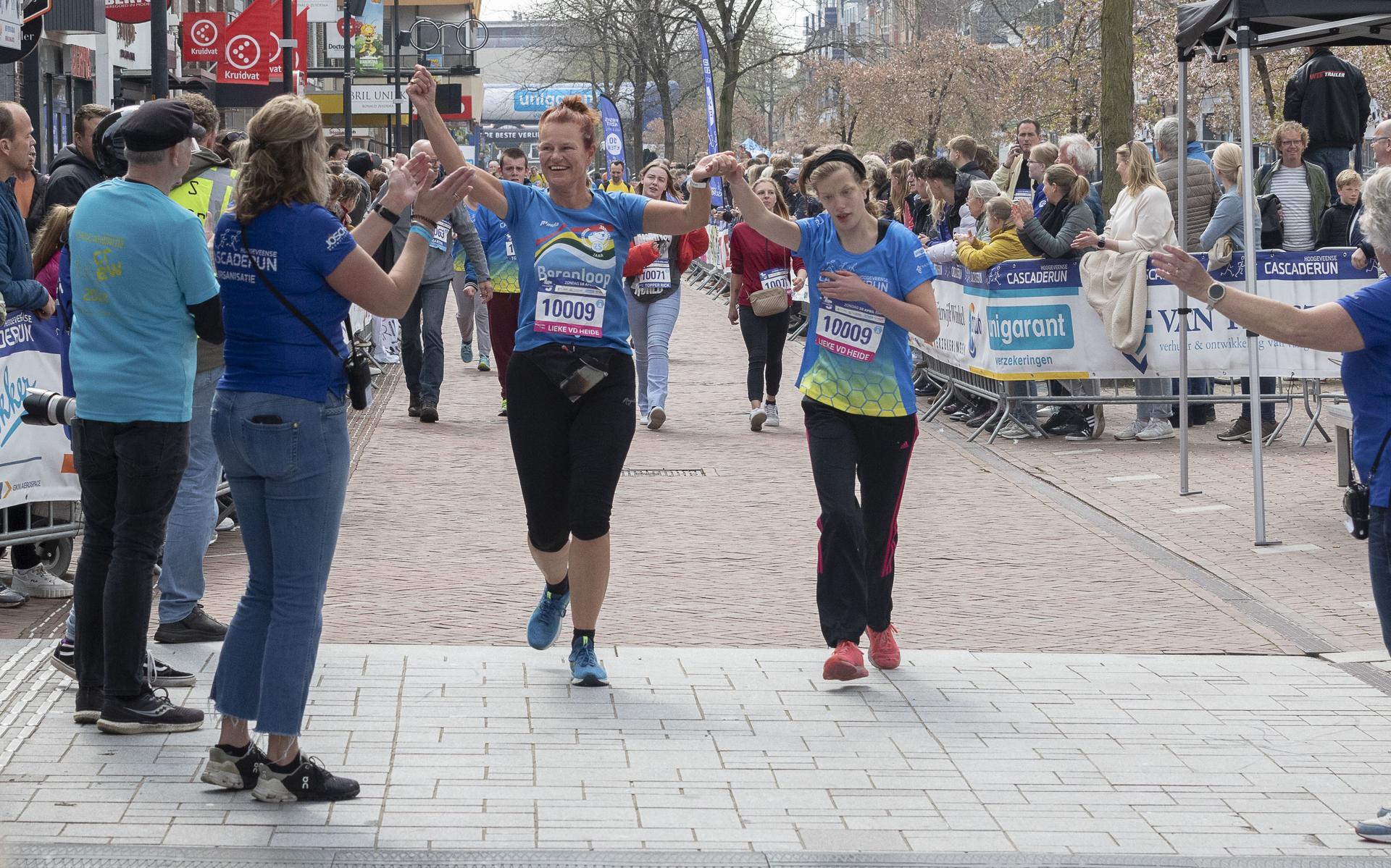 De deelnemers aan de GigaG-run lopen zo hard ze kunnen. Bij de finish terechte blijdschap.
