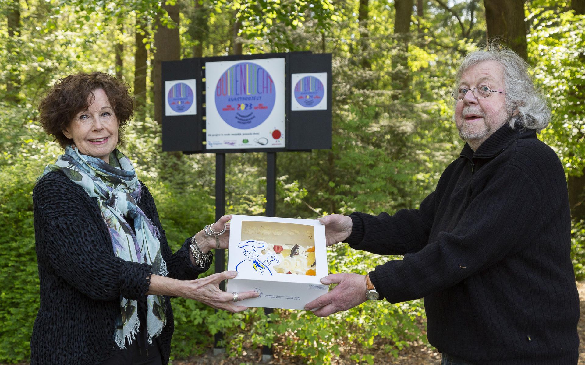 Sejo Slingenberg en Jerry Bisschop krijgen taart voor kunsttentoonstelling in het Spaarbankbos.