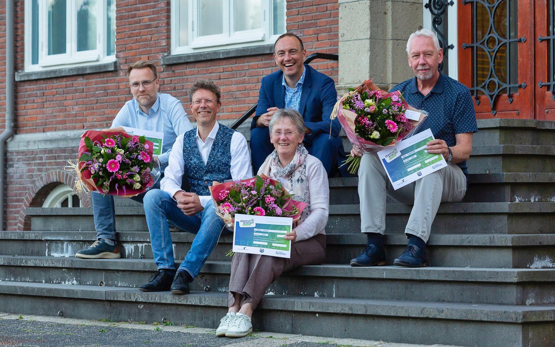 De gediplomeerde Wooncoaches met bloemen: Marcel Pomper (links), Katja Strik en Jan Hiemstra (rechts)? met op de achtergrond wethouder Westendorp.