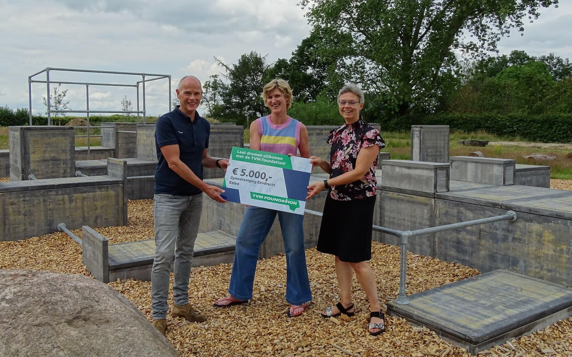 Martine Polling (SportExloo, midden) ontvangt mede namens Gymvereniging Eendracht de cheque uit handen van Gea Burger-Langius (TVM-medewerker, rechts) en Hendrik de Jonge (TVM foundation, links)