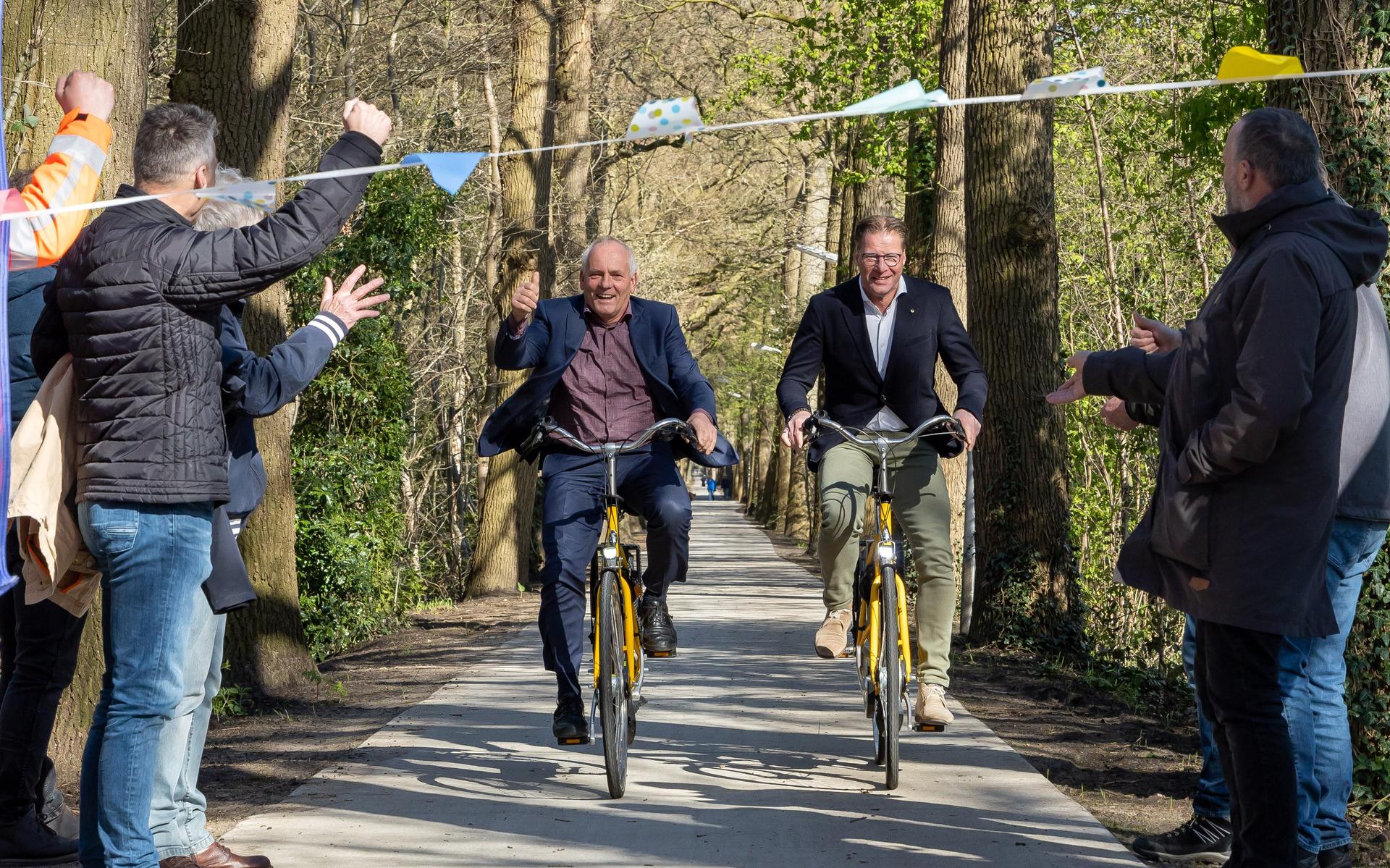 Gedeputeerde Henk Brink (links) en wethouder Roelof Bisschop openen het vernieuwd fietspad Kerkhoflaan. 