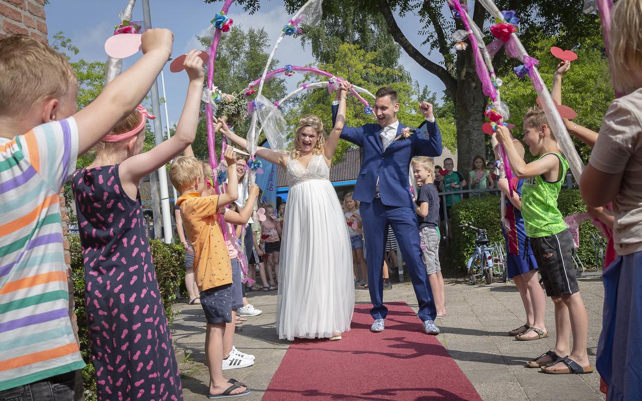 De leerlingen maakten een feestelijke erehaag voor het bruidspaar. De leerlingen maakten een feestelijke erehaag voor het bruidspaar.