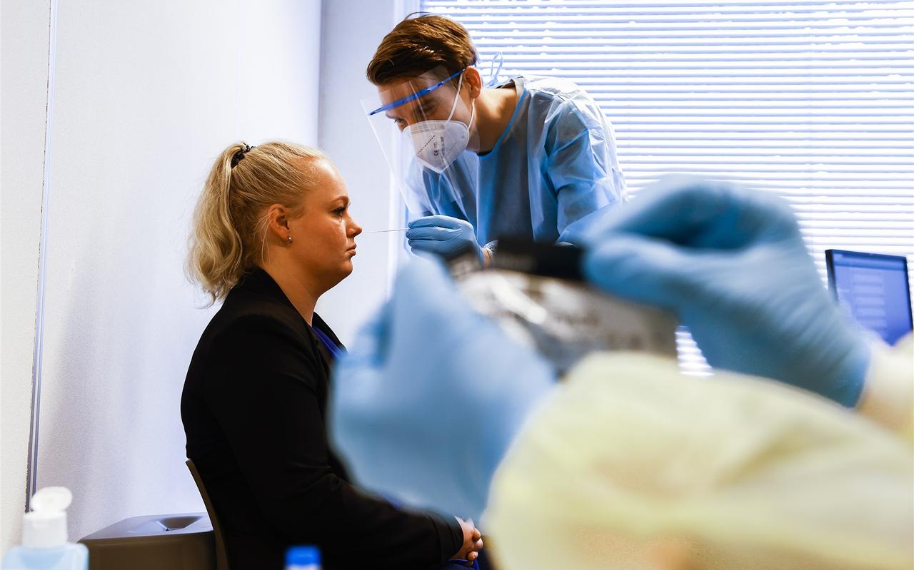 Een medewerker van de GGD neemt een coronatest af. Een medewerker van de GGD neemt een coronatest af.
