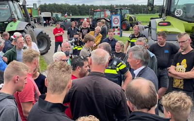 Burgemeester Cees Bijl en agenten staan tussen de protesterende boeren in Wijster.
