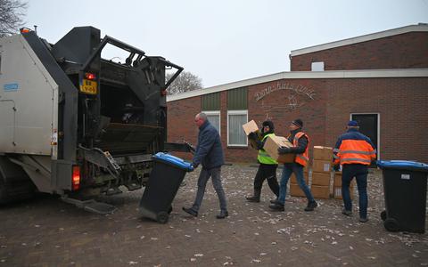 Voor de laatste keer werd in december het oud papier door vrijwilligers opgehaald in Linde, zoals hier bij het dorpshuis.  Al die losse dozen bij de container, dat mag na 1 januari niet meer.